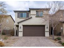 Beige two-story home featuring a brown two-car garage and a brick driveway at 2240 Sky Island Dr, Henderson, NV 89002