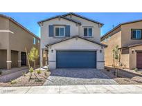 Two-story home with gray siding, blue garage door, and landscaping at 2633 Snapdragon Falls Ave, North Las Vegas, NV 89081