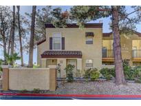 Charming two-story condo with stucco exterior, mature trees, and well-maintained landscaping at 2801 N Rainbow Blvd # 255, Las Vegas, NV 89108