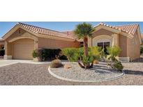 Tan one-story house with tile roof, desert landscaping, and two-car garage at 3021 Isaac River Dr, Las Vegas, NV 89134