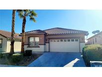 Tan house with tile roof, two-car garage, and desert landscaping at 3317 Barada Heights Ave, North Las Vegas, NV 89081