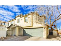 Two-story home featuring an attached garage, neutral stucco, covered entryway, and well-kept landscaping at 6356 Blue Twilight Ct, Las Vegas, NV 89108