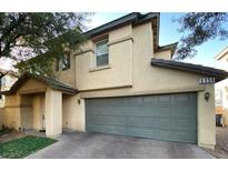 Two-story house with gray garage door and tan exterior at 6356 Blue Twilight Ct, Las Vegas, NV 89108