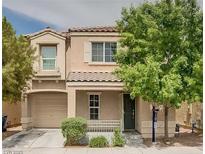 Two-story house with tan siding, a dark-gray door, and a well-manicured lawn at 7732 Hand Woven Ct, Las Vegas, NV 89149