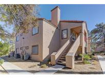 Lovely two-story condo featuring a beige exterior with a red tile roof and well-maintained landscaping at 9070 Spring Mountain Rd # 113, Las Vegas, NV 89117