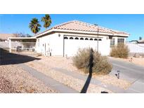 Cozy single-story home featuring desert landscaping, a two-car garage, and a gated carport at 1214 Emerald Stone Ave, North Las Vegas, NV 89081