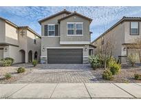 Two story house with gray siding, dark garage door and landscaped yard at 2962 Torreon Ln, Las Vegas, NV 89121