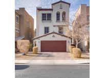 Two-story house with a red door and landscaped yard at 345 Gracious Way, Henderson, NV 89011