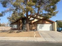 Two-story house with attached garage and mature tree in front yard at 4684 Trevins Ave, Las Vegas, NV 89103