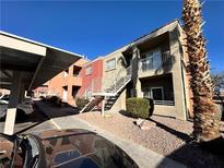 Two-story condo with a red-tile roof, landscaped ground cover and metal stairs to an upstairs unit at 4730 E Craig Rd # 1100, Las Vegas, NV 89115