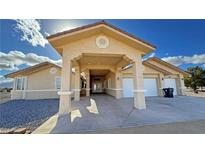 Inviting home exterior showcasing a covered drive, well-maintained stucco, and a two-car garage at 1771 Labrador St, Pahrump, NV 89048