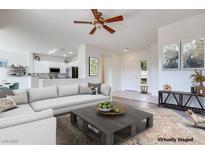 Bright living room featuring a comfortable sofa, stylish decor, and an open layout connecting to the kitchen at 2741 Meadow Park Ave, Henderson, NV 89052