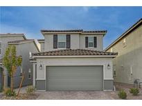 Two-story house with gray siding, gray garage door, and dark brown window shutters at 7675 W Mistral Ave, Las Vegas, NV 89113