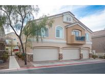 Tan three-car garage home with balcony and walkway at 1145 Amarillo Sky Pl # 3, Henderson, NV 89002