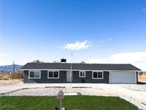 Newly constructed single-story home with gray exterior and a landscaped lawn at 1470 Sutton Dr, Pahrump, NV 89048