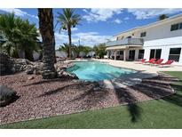Inviting backyard oasis featuring a sparkling pool, lounge chairs, and lush landscaping at 4193 W Warm Springs Rd, Las Vegas, NV 89118