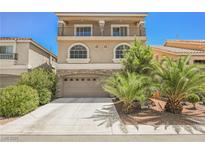 Two-story house with balcony, two-car garage, and palm trees at 9242 Midnight Cellars St, Las Vegas, NV 89139