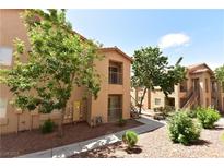 Exterior of a tan apartment building featuring landscaped grounds and second story patios at 2110 Los Feliz St # 2052, Las Vegas, NV 89156