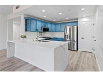 Modern kitchen featuring blue cabinets, quartz countertops, and stainless steel appliances at 2325 Windmill Pkwy # 1711, Henderson, NV 89074