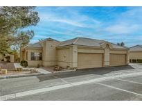 Tan stucco house with two-car garage and landscaped yard at 448 Wonderstone Dr, Las Vegas, NV 89107