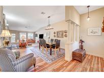 Bright, open-concept living and dining area with wood floors and vaulted ceilings at 5105 Kingsbridge Dr, Las Vegas, NV 89130