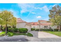 Charming home with a red tile roof, well-maintained landscaping, and a lush green lawn under a sunny, blue sky at 6914 Emerald Springs Ln, Las Vegas, NV 89113
