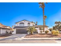 Charming two-story stucco home featuring a desert landscape, gray garage door, and inviting curb appeal at 889 Monika Way, Las Vegas, NV 89119