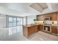 Modern kitchen with stainless steel appliances, granite countertops, and an open floor plan leading to a living area at 222 Karen Ave # 705, Las Vegas, NV 89109
