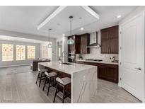 Modern kitchen features a large island with waterfall countertop and stainless steel appliances at 59 Desert Ivy Ln, Henderson, NV 89011