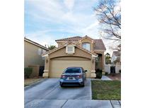 Two-story house with attached garage and landscaped yard at 8209 Cactus Canyon Ct, Las Vegas, NV 89128