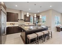 A modern kitchen features an island with bar stool seating and stainless steel appliances at 120 Los Cabos Dr # 301, Las Vegas, NV 89144
