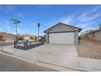 Single story home with a two-car garage and well-manicured landscaping at 4401 Mossy Rock Ct, Las Vegas, NV 89108