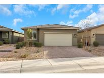 Single-story home with a two-car garage and landscaped front yard at 2261 Cold Canyon Ave, North Las Vegas, NV 89086