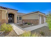 Charming single-story home features a stone facade, well-manicured landscaping, and a tile roof at 6042 Alpine Estates Cir, Las Vegas, NV 89149