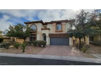 Charming stucco home featuring a two-car garage, arched windows, and mature landscaping at 8005 Egypt Meadows Ave, Las Vegas, NV 89178