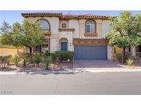 Charming two-story home featuring a tile roof, arched windows and a well-manicured front yard at 8005 Egypt Meadows Ave, Las Vegas, NV 89178