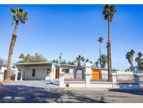 Remodeled mid-century modern home with bright orange garage doors and a gray exterior at 3212 Gaucho Dr, Las Vegas, NV 89169