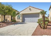Charming single-story home with a two-car garage, landscaped front yard with palm trees and desert accents at 8633 Sherwood Park Dr, Las Vegas, NV 89131