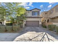 Charming two-story home with a beautiful stone driveway and well-manicured landscaping, including mature trees at 9661 Canyon Landing Ave, Las Vegas, NV 89166