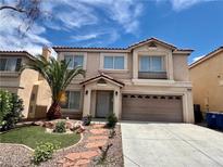 Charming two-story home featuring a desert landscaped front yard with a two car garage and light tan paint at 10618 Timber Stand St, Las Vegas, NV 89183