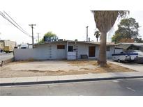 Exterior view of a single-story house with block wall and a desert style front yard with some trees at 1836 Mcdaniel St, North Las Vegas, NV 89030