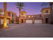 Elegant stucco home boasts stone accents, tile roof, and palm trees with paver driveway in a private community at 24 Cerchio Alto, Henderson, NV 89011