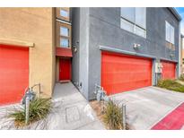 Modern building exterior with red garage doors and a red front door at 247 Dougram Ave, Las Vegas, NV 89101