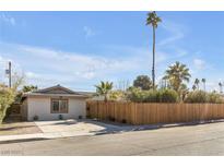 Single story home with wood fence, driveway, and palm trees at 3398 El Camino Real, Las Vegas, NV 89121