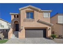 Two-story house with tan exterior, brown garage door, and landscaped yard at 752 Golden Sedum Dr, Henderson, NV 89011