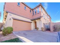 Two-story townhome featuring a large garage and a secure gated entrance at 8523 Peaceful Dreams St, Las Vegas, NV 89139