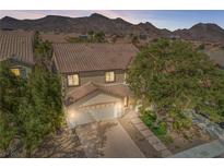 Charming two-story home with a brick driveway, mature trees, and a mountain backdrop at 1163 Highbury Grove St, Henderson, NV 89002