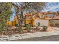 Charming single-story home with a well-manicured front yard and a two-car garage, complemented by lush landscaping at 1424 Desert Hills Dr, Las Vegas, NV 89117