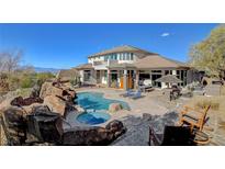 An outdoor pool, hot tub and patio area is surrounded by desert landscaping, lounge chairs and multiple seating areas at 3 Chenal Pass, Henderson, NV 89052