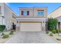 Charming two-story home with a neutral color palette and a well-maintained, brick-paved driveway and desert landscaping at 387 Layla Bay St, Henderson, NV 89014